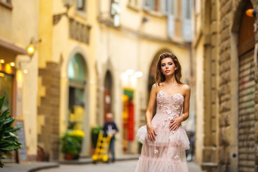 A bride in a pink wedding dress walks in Florence, Italy.