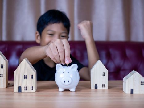 Boy saving money in a white pig piggy bank.Saving concept. Saving for the future.