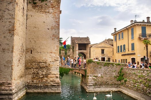 Sirmione, Italy-October 9, 2018: People relax in the town of Sirmione near the castle of Scaligera.