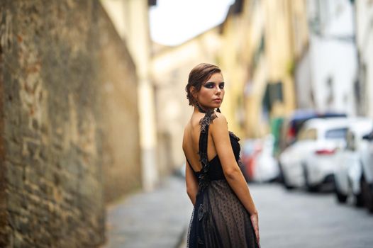 A beautiful stylish bride in a black dress walks through Florence, a Model in a black dress in the old city of Italy.