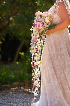 an unusual elongated wedding bouquet in the hands of the bride.