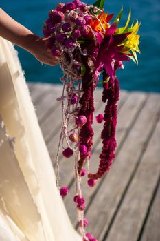 an unusual elongated wedding bouquet in the hands of the bride.