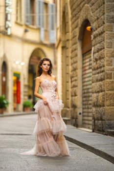 A bride in a pink wedding dress walks in Florence, Italy.