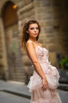 A bride in a pink wedding dress walks in Florence, Italy.