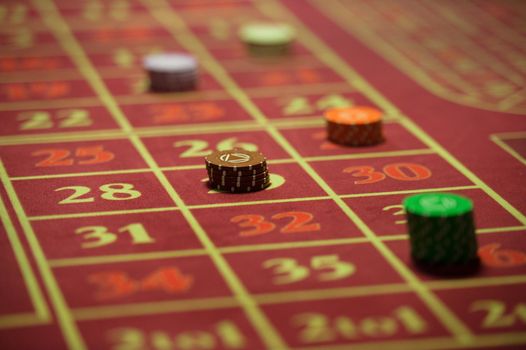 close-up of casino chips on the red table.