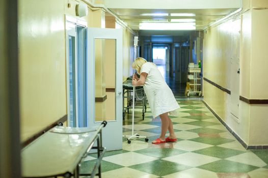 A pregnant woman stands in the corridor of a maternity hospital before giving birth.
