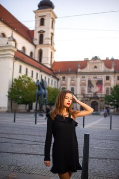 Stylish young girl in a black dress on the street of the city of BRNO in the morning.Czech.