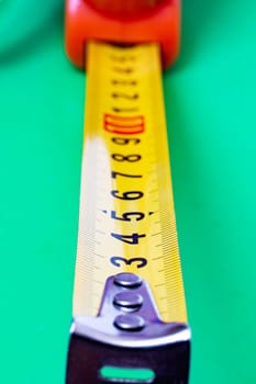 Measuring tape on a green background close up