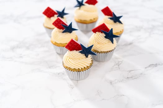 Lemon cupcakes with lemon buttercream frosting, and decorated with patriotic blue chocolate star and red mini chocolate.