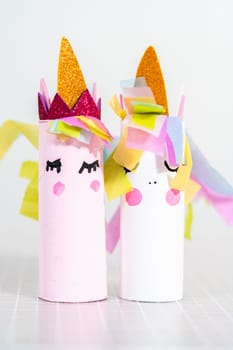 Making a unicorn out of the toilet paper roll and craft paper.