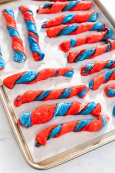 Rising patriotic cinnamon twists on the baking sheet lined with parchment paper.