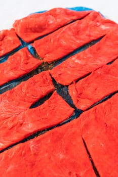 Rolling red and blue bread dough to bake patriotic cinnamon twists.