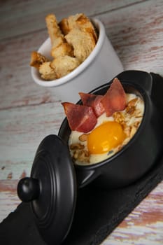 Recipe Oeuf cocotte with fresh cream sauce, Roquefort and walnuts, ham chips, toasted bread sticks. High quality photo
