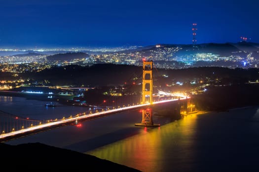 Golden Gate Bridge and lights from hilly city of San Francisco at night. High quality photo