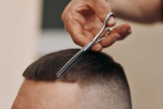 master hairdresser does hairstyle with scissors and comb. close-up