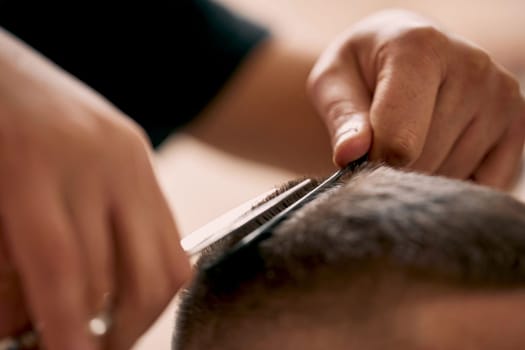 master hairdresser does hairstyle with scissors and comb. close-up
