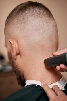 Barber shaving handsome bearded man in barber shop.