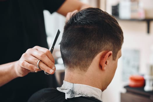 master hairdresser does hairstyle with scissors and comb.