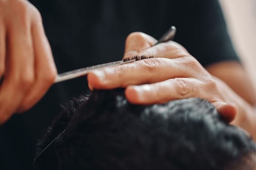 hairdresser does haircut for caucasian man in barber shop. close-up