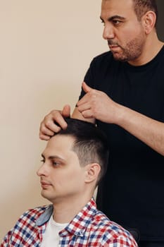 Barber and satisfied bearded man in front of the mirror in barber shop