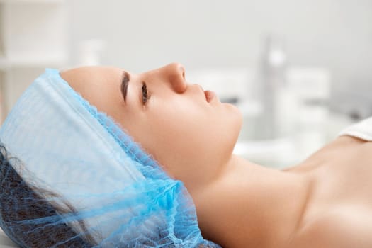 young beautiful woman at spa salon. female face with healthy smooth soft skin, profile