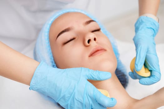 beautician cleanses skin of beautiful woman with sponge. close-up. Perfect cleaning, spa treatment skincare face.