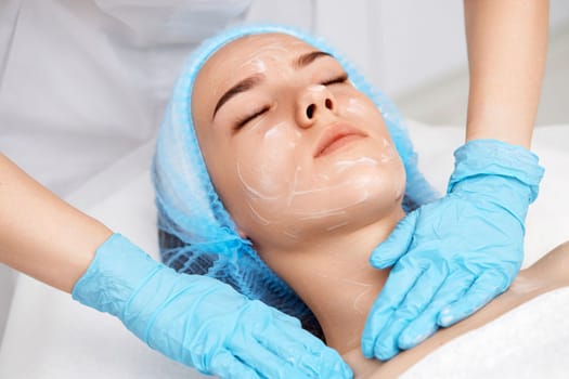 young beautiful woman receiving facial massage at spa salon