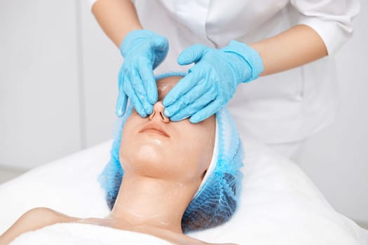 young beautiful woman receiving facial massage at spa salon