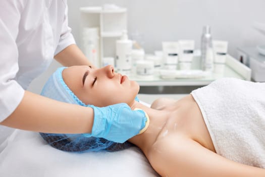 beautician cleanses skin of young woman with sponge. Perfect cleaning, spa treatment skincare face.