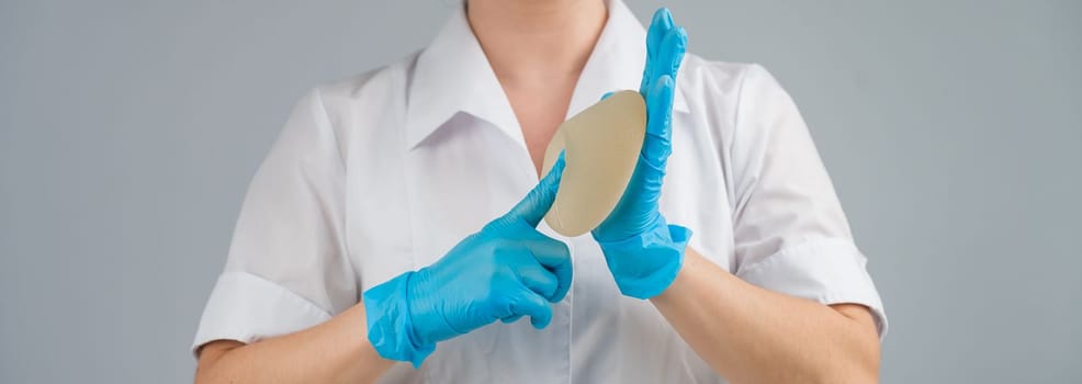 A plastic surgeon shows a breast silicone implant