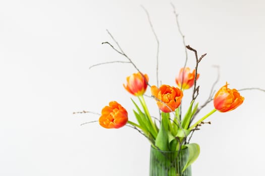 A very beautiful spring bouquet in a green vase stands on a table on a linen tablecloth, orange peony tulips. Mother's Day, March 8, Valentine's Day. Place for an inscription