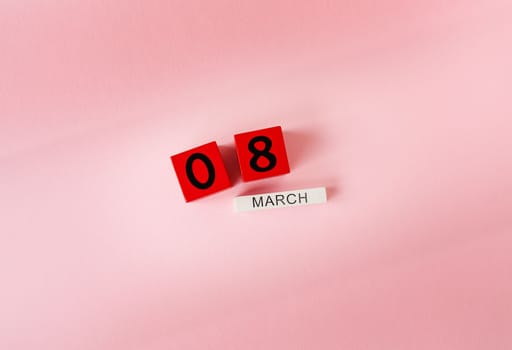 Wooden cubes with the inscription March 8 on a pink background, the inscription of a happy women's day. Ready card for the holiday, Women's Day