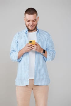 handsome unshaven guy with smartphone surfing internet. Online communication.