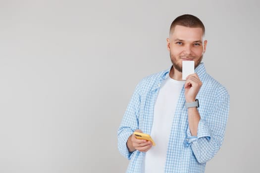 handsome man with smartphone and credit bank card shopping online. copy space