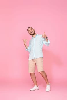 cheerful young happy man dance on pink background. vacation summer. Full body