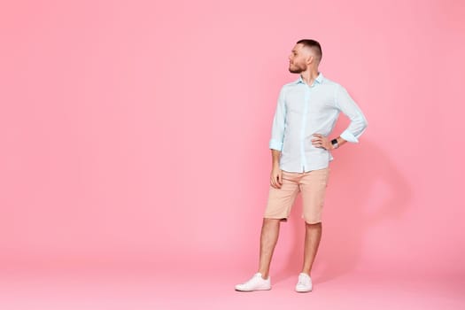 thoughtful young man looking at the copy space and thinking isolated on pink background. Full length