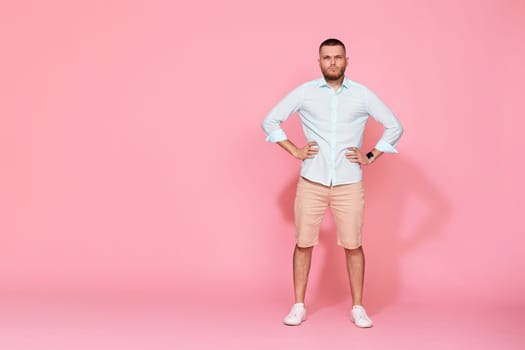 serious confident young man looking at the camera and thinking isolated on pink background. Full length. copy space