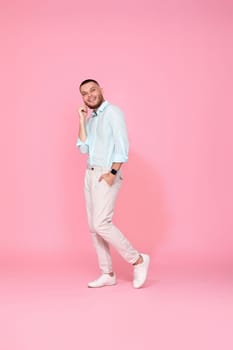 young caucasian smiling bearded man wearing casual shirt isolated on pink background. Full length