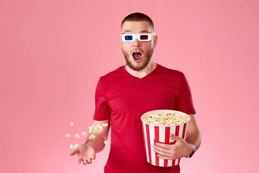 surprised man in 3d glasses throwing up and eating popcorn on pink background
