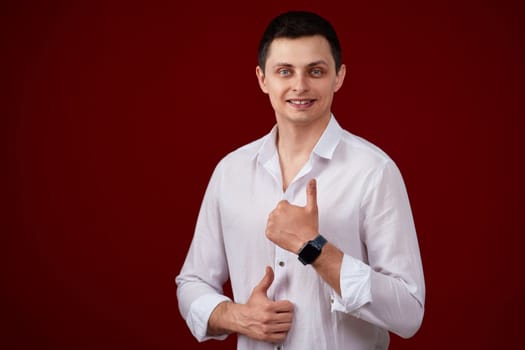 brunette man in t-shirt smiling and showing ok sign isolated on pink background