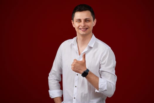 brunette man in t-shirt smiling and showing ok sign isolated on pink background