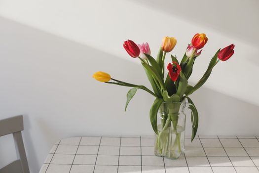 Colorful fresh tulips on a light background.