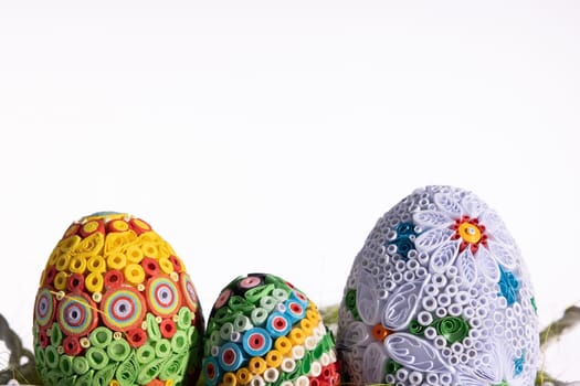 A masterpiece of handmade Easter eggs can be seen on a uniform clean background. Ornaments in honor of the Christian holiday.