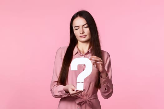 beautiful caucasian woman with question mark on pink background