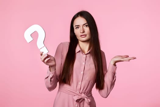 beautiful caucasian woman with question mark on pink background