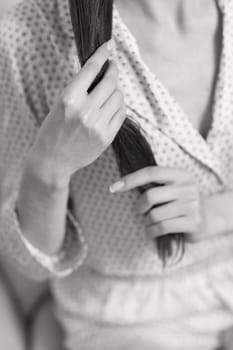 female hands hold long smooth hair. black and white