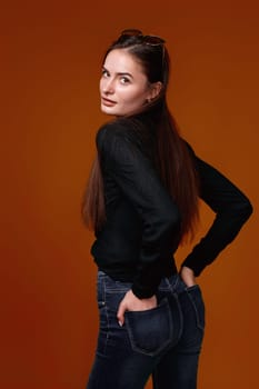 woman in black shirt and jeans on color studio background.
