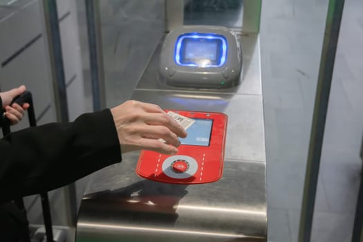 young woman scanning an e-ticket at the terminal at the subway gate. High quality photo