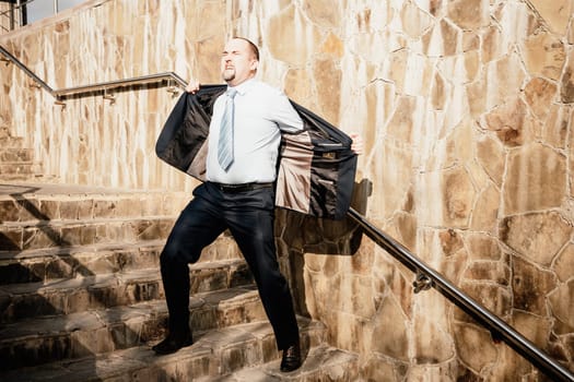 Portrait of a senior professional man in a suit with various problems. A middle-aged businessman with a briefcase descends the stairs.