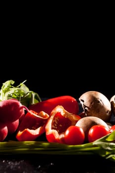 Artistic image of different type of healthy organic vegetables on dark background in studio photo